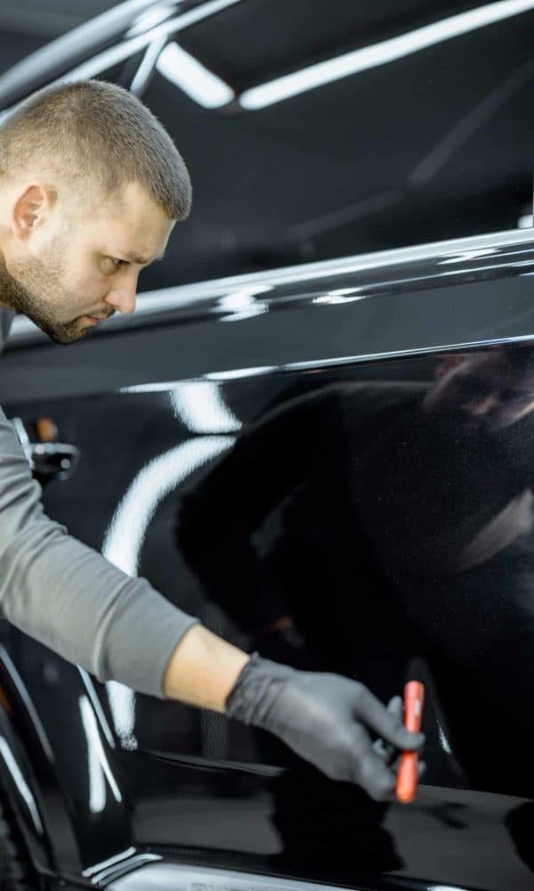 worker-examining-vehicle-body-for-scratches-2021-09-01-12-15-37-utc-scaled-qdnr72gxvosx22dkegvsq54ellnky2m0oa3ojdjf9s